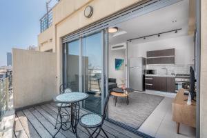 a balcony with tables and chairs on a building at Superb 1,5 BDR W balcony close to the beach in Tel Aviv