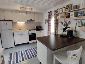 a kitchen with white cabinets and a wooden counter top at Villa Kesäranta in Jämsä