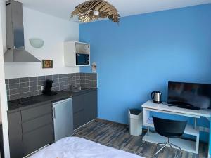a kitchen with blue walls and a bed in a room at ALOHA in La Grande Motte