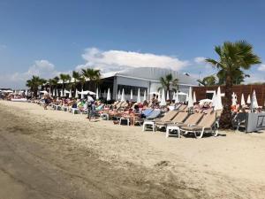 a group of people sitting in chairs on the beach at ALOHA in La Grande Motte