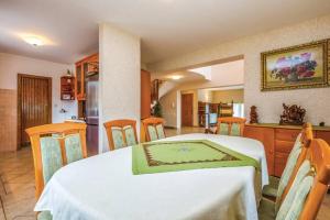 a room with a table and chairs and a kitchen at Lux apartman LEO in Kostrena