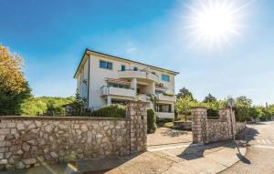 une maison avec un mur en pierre et le soleil dans l'établissement Lux apartman LEO, à Kostrena