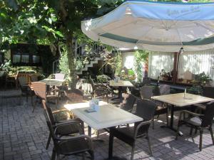 an outdoor restaurant with tables and chairs and an umbrella at Weinhaus Berg in Bremm