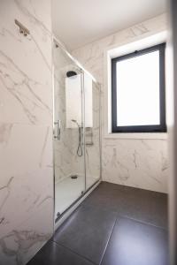 a white bathroom with a shower with a window at MyTrip Porto in Matosinhos