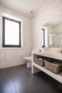 a bathroom with a sink and a toilet and a mirror at MyTrip Porto in Matosinhos