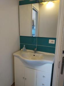 a bathroom with a white sink and a mirror at Villa "Maritima" in SantʼAndrea