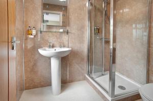 La salle de bains est pourvue d'un lavabo et d'une douche. dans l'établissement The Twice Brewed Inn, à Bardon Mill