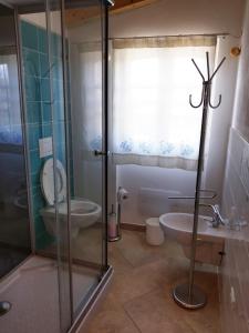 y baño con ducha, aseo y lavamanos. en Villa "Maritima" en SantʼAndrea