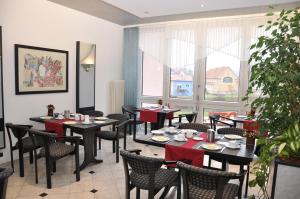a dining room with tables and chairs and a window at AltstadtHotel an der Werra in Meiningen
