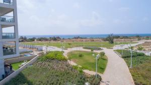 - une vue sur un parc à côté d'un bâtiment dans l'établissement Stylish Garden Apartment Close to Akhziv Beach by Sea N' Rent, à Nahariya