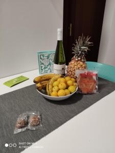 una mesa con un bol de fruta y una botella de vino en Tesbabo Beach, en La Restinga