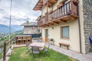 a balcony of a house with a table and chairs at Casa Alpina - Sarre in Aosta