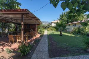 a patio with a table and chairs in a yard at Ugur Pansiyon Bungalows in Cıralı