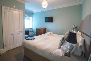 a bedroom with a large white bed with a lamp on it at Bay Tree Broadstairs in Broadstairs