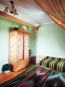a room with a bed and a wooden cabinet at Borsuki pod Lipą in Sarnaki