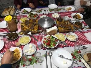 uma mesa com pratos de comida numa mesa em Guest House Sabriu em Rabdisht