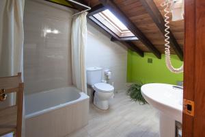 a bathroom with a toilet and a tub and a sink at Hotel Rural Porrua in Porrúa