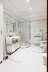 a bathroom with a shower and two sinks and a tub at B&B La Corte in Mese