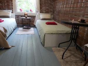 een kamer met 2 bedden, een tafel en een bakstenen muur bij Namas su lauko terasa Palangoje in Palanga
