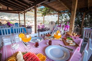 a table with a pink table cloth with food on it at Papermoon Hotel & Apartments in Kalkan