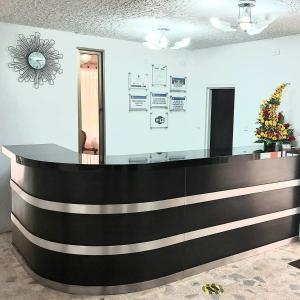 a lobby with a black and white reception desk at Hotel Emperador in Barbosa