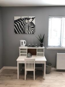 a white desk with a zebra picture on the wall at The Chalet in Inverness