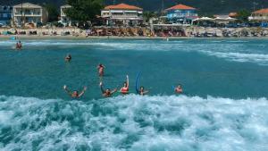 a group of people in the water at a beach at Endless Blue Sea Resort in Skala Potamias