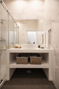 a white bathroom with a sink and a mirror at MyTrip Porto in Matosinhos