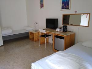 1 dormitorio con escritorio, ordenador y cama en Hotell Milano, en Åstorp