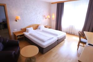 ein Hotelzimmer mit einem Bett und einem Sofa in der Unterkunft Stadthotel Pinkafeld in Pinkafeld