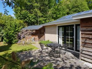 a patio with a table and chairs in a yard at Bungalow Veluwemeer in Ermelo