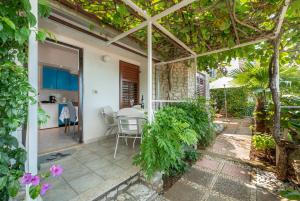 a patio with a table and chairs and trees at Apartments Mandica in Rabac