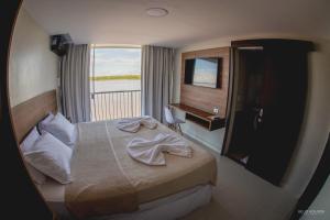 a hotel room with a bed and a window at Hotel Orla do Rio Branco in Boa Vista