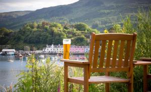 a wooden bench sitting on top of a lush green hillside at Cuillin Hills Hotel in Portree