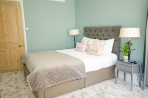 1 dormitorio con 1 cama con sábanas blancas y almohadas rosas en Seaview Mansion Apartment - Central Hove with PARKING, en Brighton & Hove