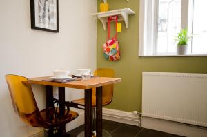 una mesa pequeña con 2 sillas y una mesa con tazas en Seaview Mansion Apartment - Central Hove with PARKING, en Brighton & Hove