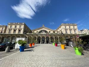 un gran edificio con macetas delante de él en Paris Canal Studio - Gare de l'Est en París