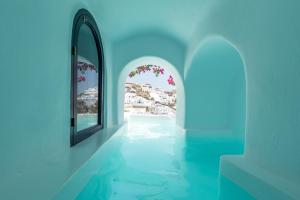 a hallway with a window and a view of a beach at Chelidonia Luxury Suites in Oia