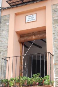 un edificio con un balcón con un cartel. en Casa de Amparo y José Manuel, en Pavías
