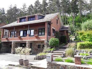 une grande maison en briques avec des escaliers dans une cour dans l'établissement Ô Vert'jardin, à Rochefort