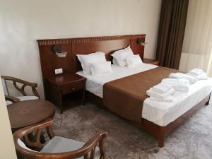 a hotel room with a bed with towels on it at Pensiunea JOJO Imperial Resort&Spa in Băile Herculane +30 photos