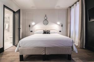 a bedroom with a large white bed and a bathroom at LUXURY SANTO STEFANO in Venice