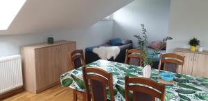 uma sala de jantar com mesa e cadeiras em Pokoje Gościnne 4 Pory Roku em Klimkówka