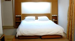 1 cama con 2 almohadas y una ventana en una habitación en Katerina Hotel, en Kozani