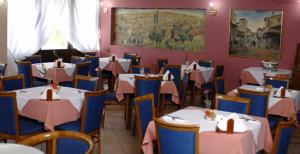 a restaurant with white tables and blue chairs at Katerina Hotel in Kozani