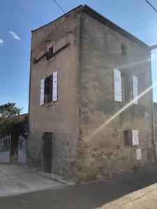 ein altes Backsteingebäude mit weißen Fenstern auf einer Straße in der Unterkunft La Maisonnette auvergnate in Vertaizon