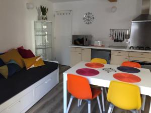 uma cozinha com uma mesa e quatro cadeiras em La Maisonnette auvergnate em Vertaizon