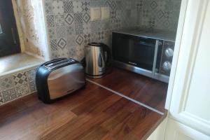 a microwave and a toaster sitting on a wooden floor at Traditional stone house in Sitia