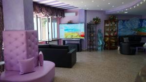 a living room with purple walls and a large screen at Hotel Albatros in Roseto degli Abruzzi