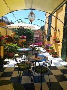 un patio al aire libre con mesas, sillas y flores en Locanda Il Maestrale, en Monterosso al Mare